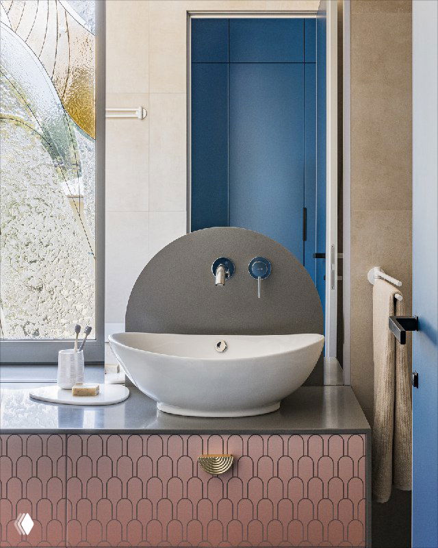 Ванная с витражной росписью на окне: искусственный камень на откосах и подоконнике, столешница и тумба с розово-оранжевым градиентом и ручками.