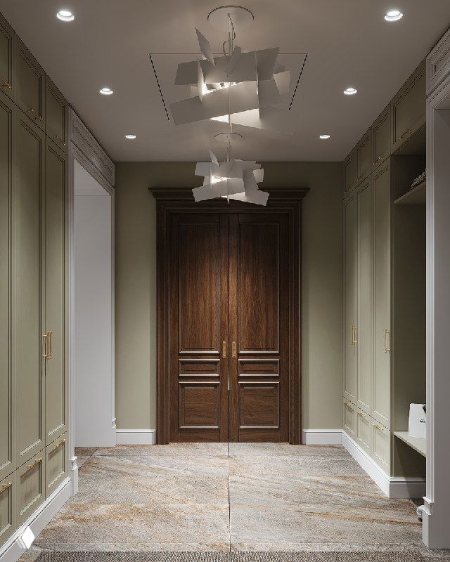 Деревянная двустворчатая дверь в прихожей, отделка темного дерева на фоне стен с классической лепниной и встроенными шкафами.