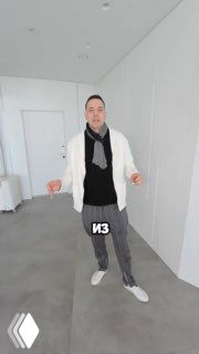 Человек в светлой одежде на фоне минималистичной комнаты с белыми стенами и серым полированным полом — превью интерьера.