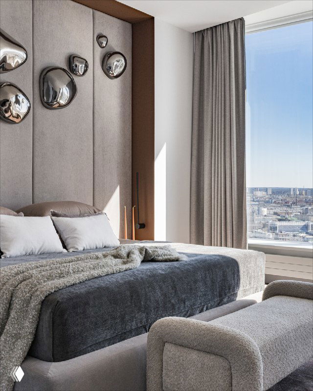 Спальня в проекте «Швейцарские Альпы»: крупный план кровати king-size у панорамного окна, мягкое изголовье с декоративными металлическими каплями, текстиль в нейтральных тонах.