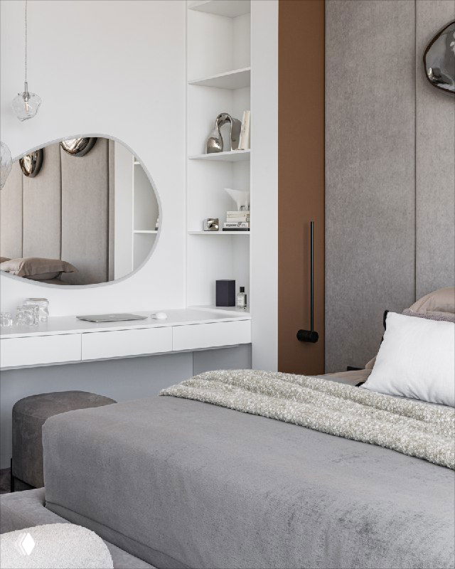 Угол спальни с белым макияжным столиком и круглым зеркалом, рядом видна часть кровати и отделка стены с декоративными элементами в спокойной цветовой гамме.