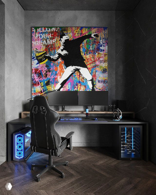 Игровой уголок подростковой комнаты: геймерское кресло, стол с подсветкой и системным блоком, над ним картина в стиле Бэнкси.