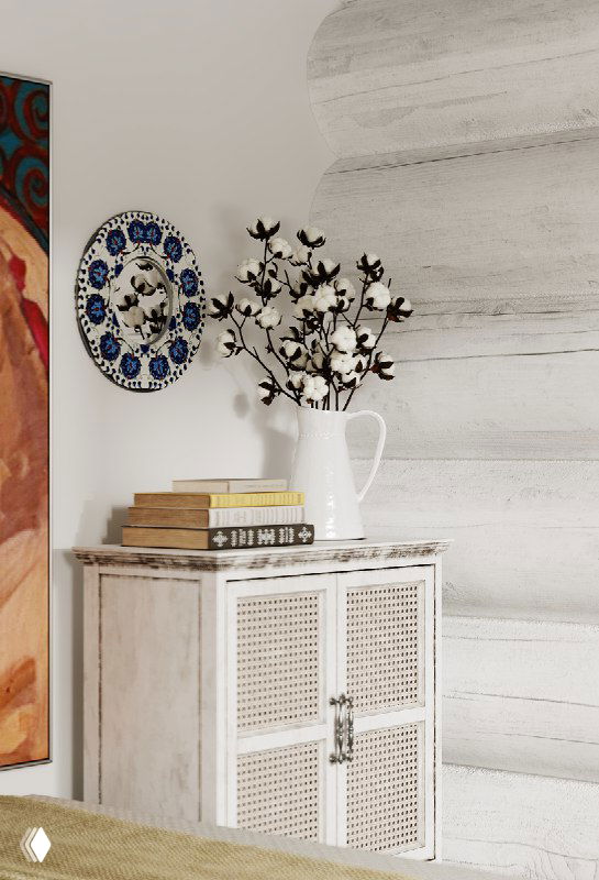Прикроватная композиция: белая тумба с плетёными фасадами, ваза с ветками, декоративная тарелка и стопка книг на фоне светлой деревянной стены.