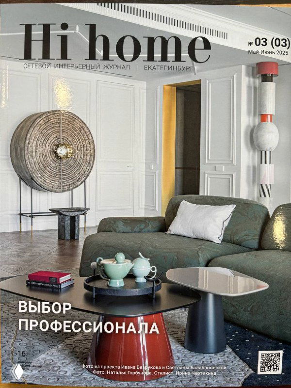 Крупный план обложки журнала Hi home: интерьер гостиной с зелёным диваном, журнальными столиками, декоративными предметами и стеклянной стойкой.