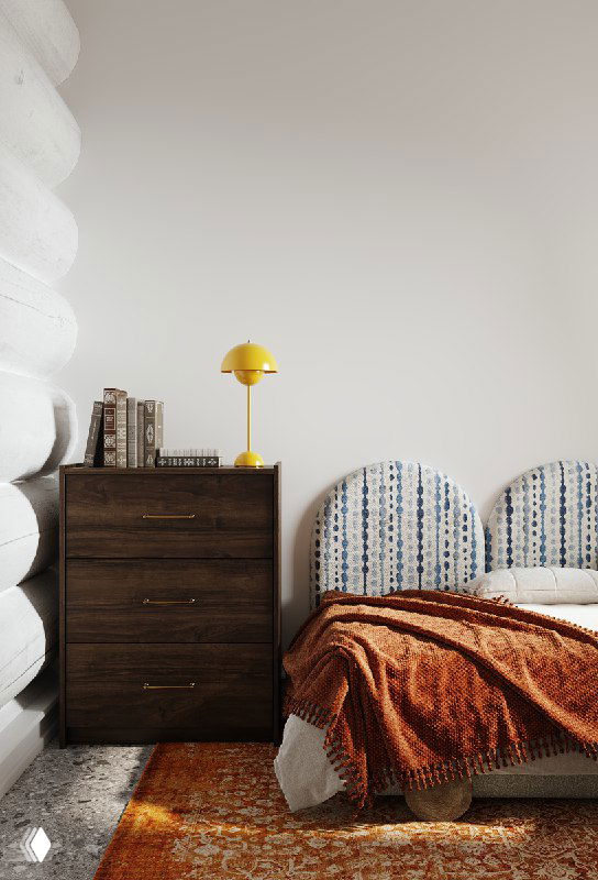 Спальня в загородном доме: бревенчатая стена, двуспальная кровать с мягкими панелями, жёлтая настольная лампа и тёплый яркий ковер в интерьере.