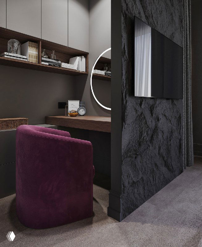 Рабочая зона за перегородкой: деревянный стол, подсвеченные полки и уютное кресло винного оттенка, показывающие компактный кабинет в спальне.