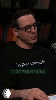 Кадр из подкаста: ведущий в очках и тёмной одежде в студии, обсуждает договоры с застройщиком на фоне книжных полок.