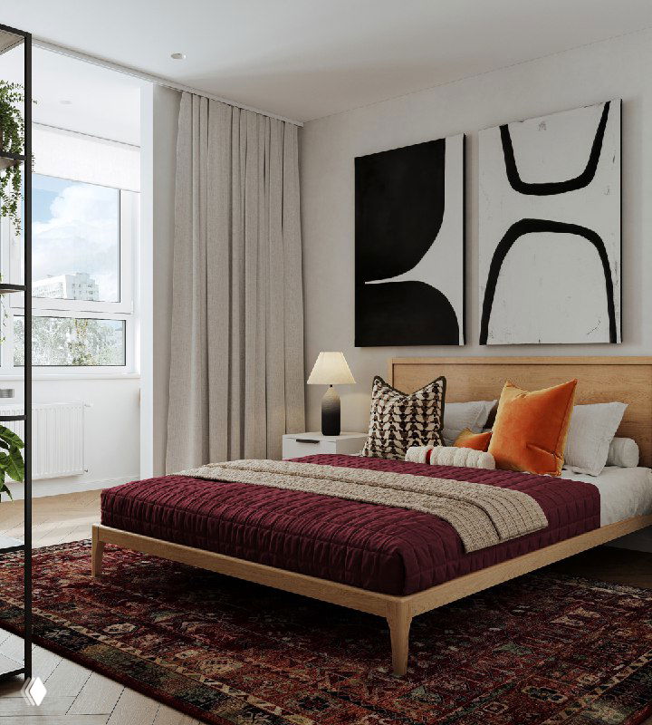 Спальня проекта: низкая деревянная кровать с бордовым покрывалом, несколько декоративных подушек, этнический ковёр на полу и большая абстрактная картина на светлой стене у окна.