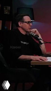 Мужчина в студии подкаста с микрофоном и ноутбуком, ведущий говорит о напольных покрытиях и дизайне интерьера.