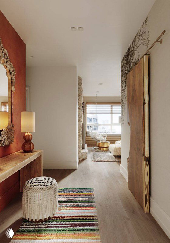 Вид узкой светлой прихожей: инженерная доска на полу, вязаный полосатый ковер у входа, пуф и открытая перспектива в жилую зону.