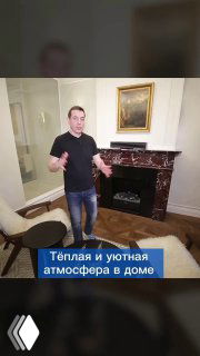 Мужчина в гостиной рядом с электрокамином и мраморным порталом Rosso Levante; кадр подчёркивает тёплую уютную атмосферу дома.