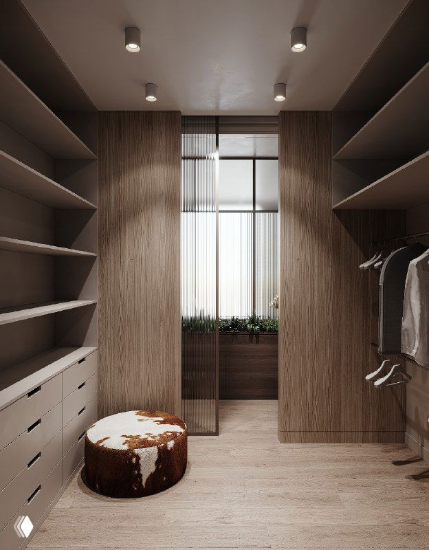 Проход в гардеробной к окну с мягким пуфом в сафари-стиле; много открытых полок и шпонированные стеновые панели, теплое освещение.