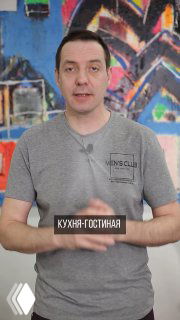 Мужчина на фоне граффити-стены держит табличку «кухня‑гостиная», кадр из видео дизайнера о планировке и зонировании.