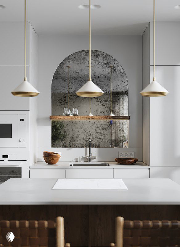 Светлая кухонная зона: гарнитур цвета стен, арочное патинированное зеркало над мойкой, минималистичные подвесные светильники и декор.