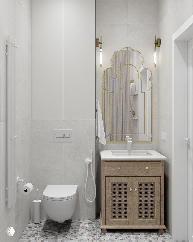 Фрагмент ванной: деревянная тумба под раковину, изящное зеркало в тонкой золотой раме и светлая плитка в этно‑минималистском интерьере.