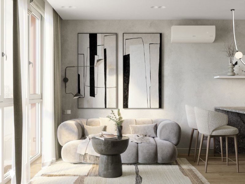 Гостиная зона с мягким округлым диваном, настенными абстрактными картинами, низким кофейным столиком и большими окнами, много света.