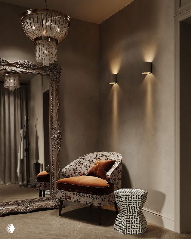 Прихожая с высоким декоративным зеркалом в полный рост, кресло с растительным узором, небольшой столик и хрустальная люстра в тёплых нейтральных тонах
