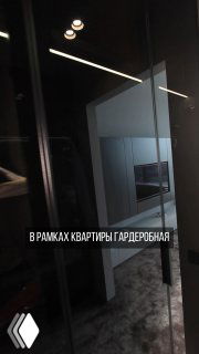 Фото интерьера с отражением в стеклянной двери и видом в коридор и кухню-гостиную, иллюстрирует расположение гардеробной в проекте