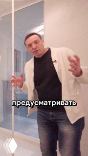 Мужчина в светлом интерьере ванной, жестикулирует и объясняет приём хранения баночек; кадр из видео-обзора проекта дизайна.