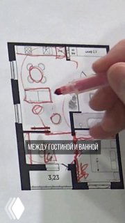 Фотография планировки с рукой, указывающей на границу между гостиной и ванной — визуализация идеи стеклянной перегородки.