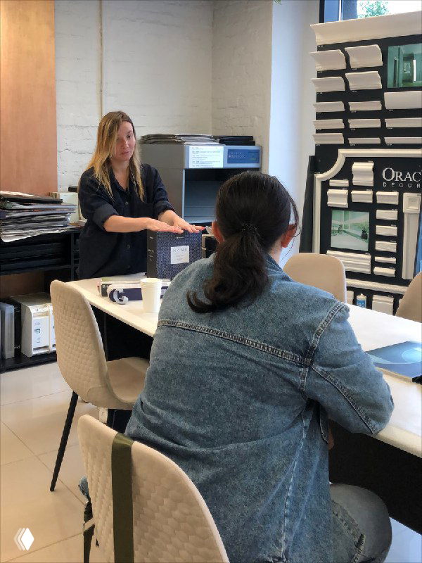 Работа с образцами в салоне: дизайнер показывает каталоги и материалы, участницы рассматривают варианты отделки и выбирают текстуры и цвета.