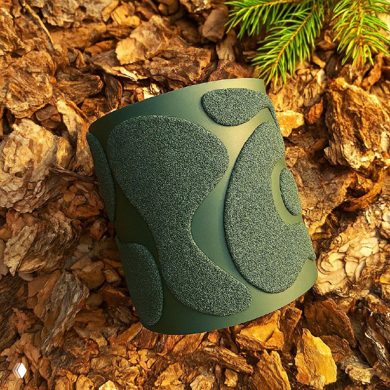 Современное зелёное кашпо с шероховатой текстурой и графическим узором, расположенное на коре или мульче — выглядит как защитный внешний слой для корней.