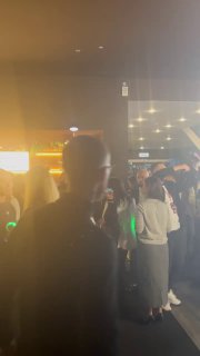 Фойе и нетворкинг после выступлений: люди в коридоре под приглушённым светом, размытый кадр передает динамику общения.