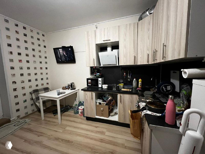 Кухонная зона с мебелью и бытовой техникой, вид с небольшого расстояния; демонстрирует практичность и состояние рабочей зоны квартиры.