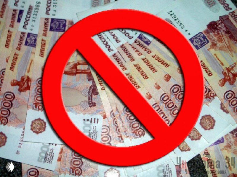 Красный знак запрета поверх стопки российских банкнот (рублей) — иллюстрация запрета наличных расчётов при покупке недвижимости.