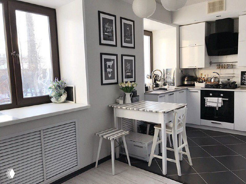 Интерьер квартиры со студийной планировкой: объединённая кухня и жилая комната с газовой плитой, столовой зоной и окном с радиатором рядом.