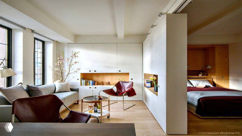 Светлая квартира с условно разделённой зоной: гостиная и спальня через перегородку, диван, кресла и пол.