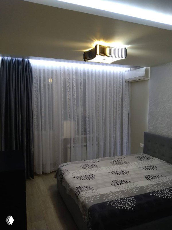 Фотография спальни после подготовки к продаже: кровать, текстиль и шторы, аккуратный интерьер и мягкое освещение, пример стейджинга.