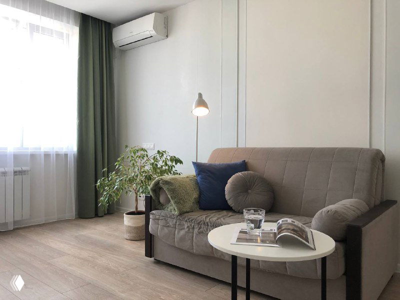 Уютный угол гостиной с креслом и торшером, акцент на естественном освещении и нейтральной цветовой палитре для потенциальных покупателей.