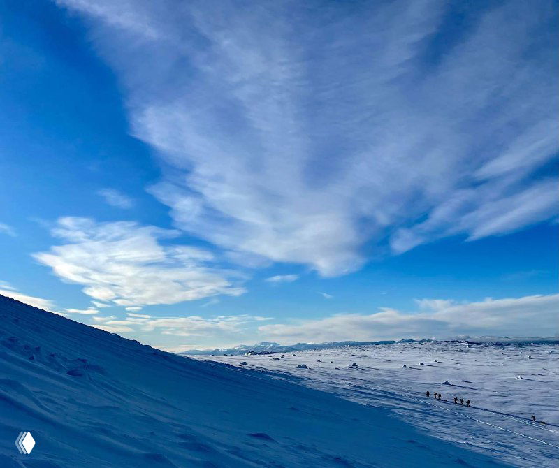 Заснеженный горный склон и широкая панорама: просторная зимняя долина и могучее небо над хребтом Большого Иремеля.