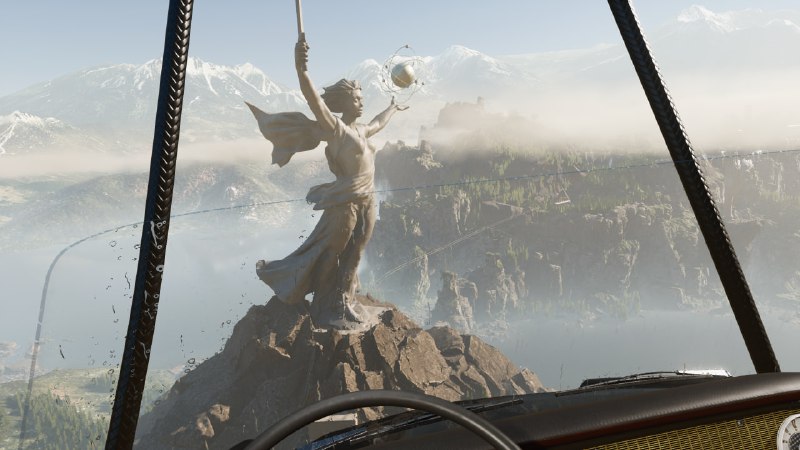 Скриншот Atomic Heart: вид с высоты на большую статую на скале, туманные горы вдали и открытое пространство, ощущение масштаба игровой локации.