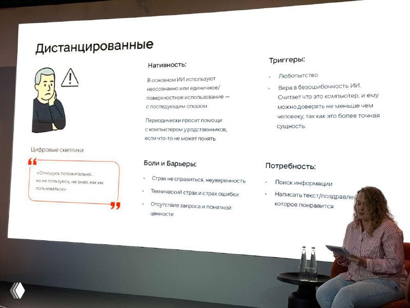 Слайд с заголовком и ключевыми тезисами конференции Silver Age, на переднем плане ведущий выступающий и часть аудитории в затемнённом зале.