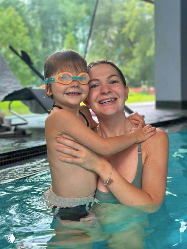Женщина и улыбающийся ребёнок в бассейне внутри аквакомплекса First&Only, кадр показывает семейную атмосферу и радость от посещения комплекса