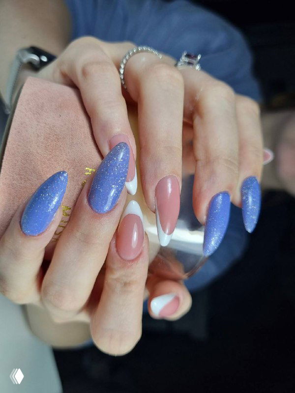 Фотография выполненного маникюра: длинные овальные ногти с сиреневым гель-лаком и френч-акцентом, съемка рук клиента в салонной обстановке.