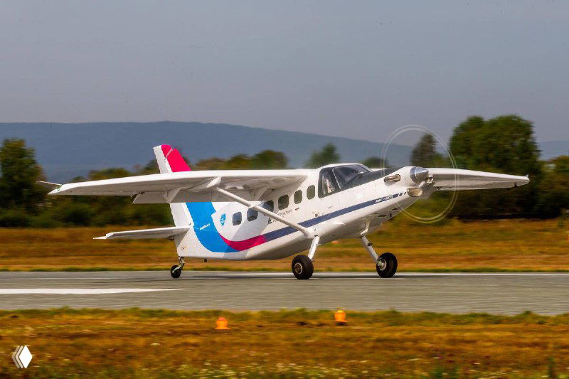 Лёгкий многоцелевой самолёт на взлётно-посадочной полосе с яркой ливреей, кадр показывает готовность к рулению и наземные испытания.