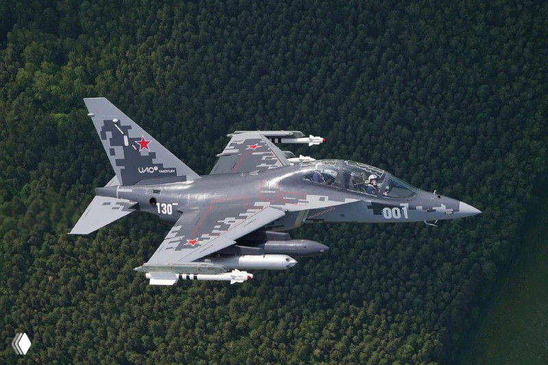 Учебно-боевой самолёт в полёте над лесным массивом, заметна подвеска внешних систем и характерная окраска на фюзеляже в демонстрационном кадре.