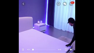 Кадр спальни с кроватью и умной тумбочкой на фоне фиолетовой подсветки, показан ночник и общая обстановка комнаты.
