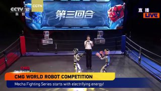 Вид арены Mech Combat Arena с ведущим в центре и двумя роботами рядом, на фоне большой сцены, табло и зрители фиксируют поединок