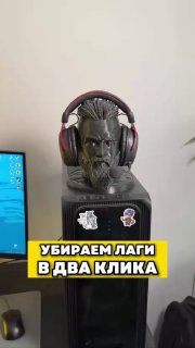 Фотография системного блока с надетыми на него наушниками, рядом виден монитор; по изображению наложена жёлтая подпись «Убираем лаги в два клика».