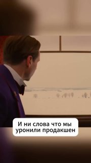 Кадр из сцены с мужчиной в костюме, смотрящим в сторону на светлый фон; поверх изображения белая подпись: «И ни слова что мы уронили продакшен».