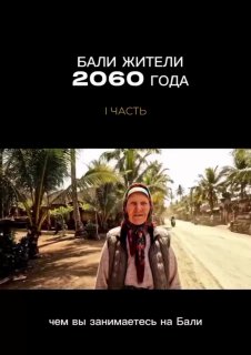 Кадр интервью: пожилая женщина стоит на дороге в поселке на Бали, за ней пальмы и домики; видеокадр с титром сверху.