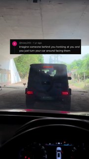 Вид из кабины на заднюю часть внедорожника Mercedes «Гелендваген» под путепроводом: видны стоп‑сигналы, задняя дверь, зеркало и приборная панель.