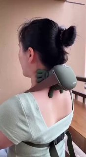 Женщина снята сзади: на верхней части спины закреплён зелёный Siaasoo N7 в форме «черепахи», массирует шею и плечи