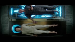 Сцена из сериала: персонаж в светлом скафандре лежит в горизонтальной криокамере, рядом стоит другой человек.