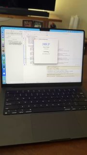 Фотография открытого MacBook на столе: на экране видно окно с настройками и кодом, подсвеченная клавиатура и часть стола.