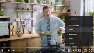 Скриншот интерфейса YouTube: ведущий на кухне, на плеере открыто меню выбора аудиодорожки, видна опция автодубляжа и субтитры.